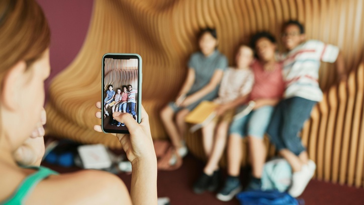 Eine Frau macht ein Foto von Kindern mit einem Smartphone